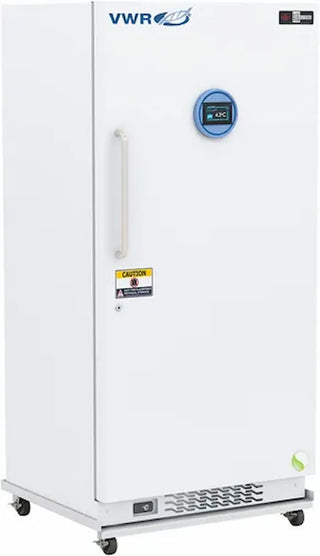 A white VWR upright chest freezer with a silver handle, featuring a yellow caution label on the door and a small green energy logo near the bottom right corner.