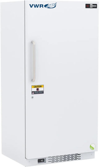 A white VWR upright chest freezer with a silver handle, featuring a yellow caution label on the door and a small green energy logo near the bottom right corner.
