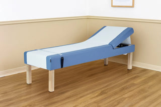 Viva Comfort ADI996-11-BLU Lucas recovery couch with exam paper in a room with wood floor