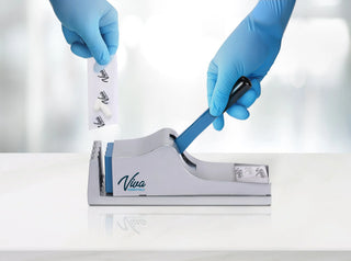 Viva Comfort ADIME950-01 gloved hands inserting a pill pouch and holding the lever on a counter