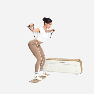 Woman training standing with the cables of the WalkingPad B2 Pilates bench
