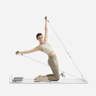 Woman performing a kneeling side stretch on the WalkingPad C1 Pilates board