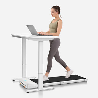 Woman working at a laptop on a standing desk while walking on the WalkingPad C1