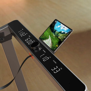 Tablet resting beside the lit console of the WalkingPad Denise Austin 2.0 treadmill