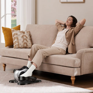 Woman relaxing on a sofa while her feet move on the WalkingPad E1 elliptical