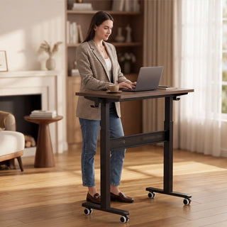 Woman working on a laptop at the raised WalkingPad ETD3 standing desk