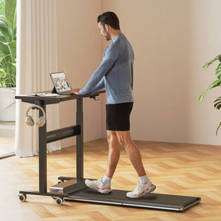 Man walking on a treadmill while working at the WalkingPad ETD3 standing desk