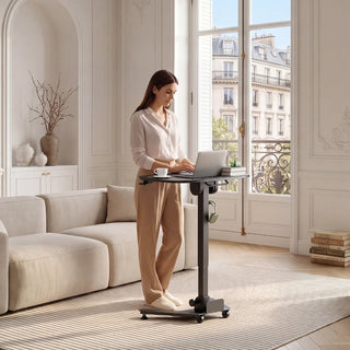 Woman working at the WalkingPad ETD5 standing desk beside a window