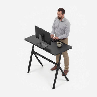 Man working standing at the black WalkingPad ETD6 standing desk