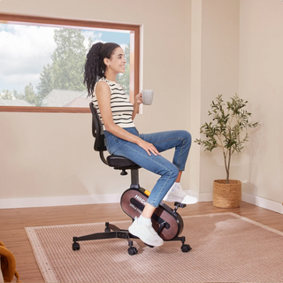 Woman sitting with a cup on the WalkingPad FC1 office bike chair at home