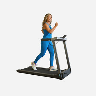 Woman walking on the WalkingPad G1 Denise Austin treadmill holding the side handle