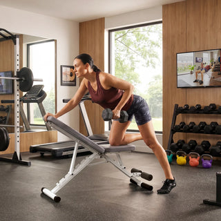 Woman adjusting the backrest of the WalkingPad MATE-FB1 weight bench in a home gym
