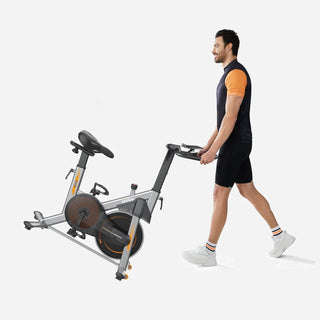 Man tilting the WalkingPad MRB2 exercise bike onto its transport wheels