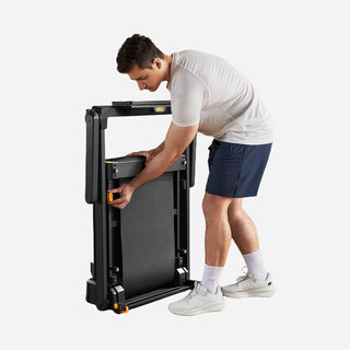 Man folding the WalkingPad MX10 treadmill deck upright against the frame
