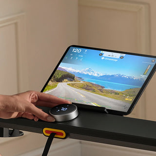 Hand using the SpeedDial knob beside a tablet on the WalkingPad MX8 tray