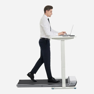 Man in office clothes walking on the WalkingPad P1 Classic treadmill at a standing desk