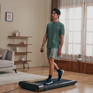 Man walking on the WalkingPad R3 treadmill in a living room
