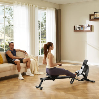 Woman rowing on the WalkingPad RM1 while a man sits on a sofa behind her