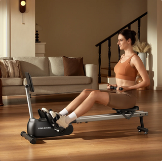 Woman rowing on the WalkingPad RW001 in a living room