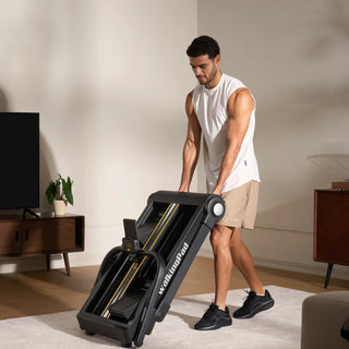 Man folding the WalkingPad Stair Stepper in a living room