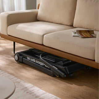 Folded WalkingPad Stair Stepper tucked under a sofa in a living room