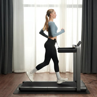 Woman running on the WalkingPad X214 treadmill beside a window