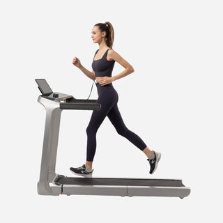 Woman running on the WalkingPad X218 treadmill with a laptop on the console shelf