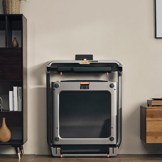 WalkingPad X218 treadmill folded and stored upright against a wall