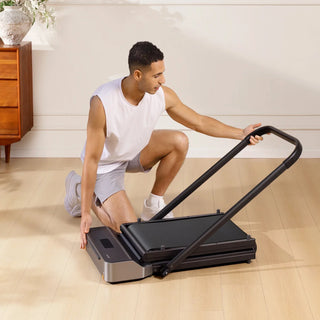 Man folding the handrail of the WalkingPad Z1R treadmill down over the deck