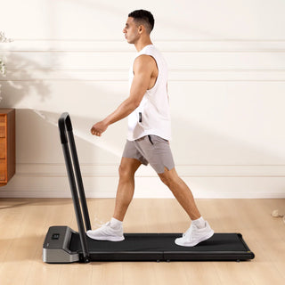 Man walking on the WalkingPad Z1R treadmill with the handrail attached in a sunlit room