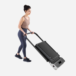 Woman wheeling the folded WalkingPad Z1R treadmill by its handrail