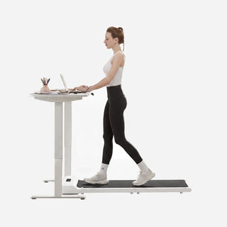 Woman walking on the WalkingPad Z1 White treadmill at a standing desk