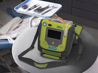 ZOLL AED on a table with medical tools in the background
